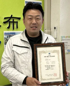 雨漏り鑑定士の資格証を持つスタッフ